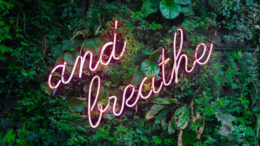 Illuminated words "and breathe" remind us to reduce stress with breathing exercises.