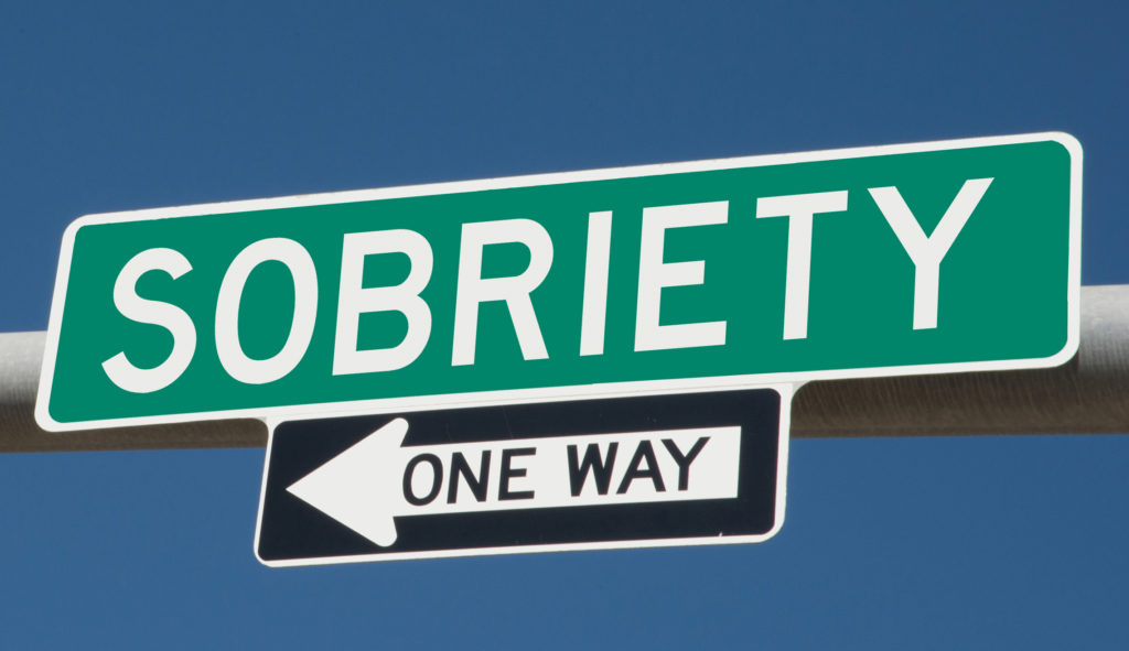 Sobriety printed on green overhead highway sign with one way arrow re minds us to pray a short prayer for National Sober Day.